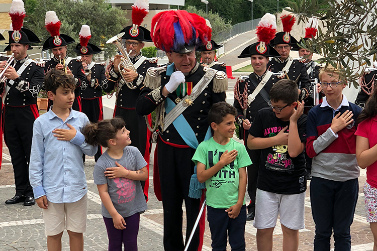 La Banda dei Carabinieri coinvolge alcuni dei bambini presenti a cantare l’Inno Nazionale